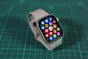 Close-up of a smartwatch showcasing various colorful app icons on its screen.